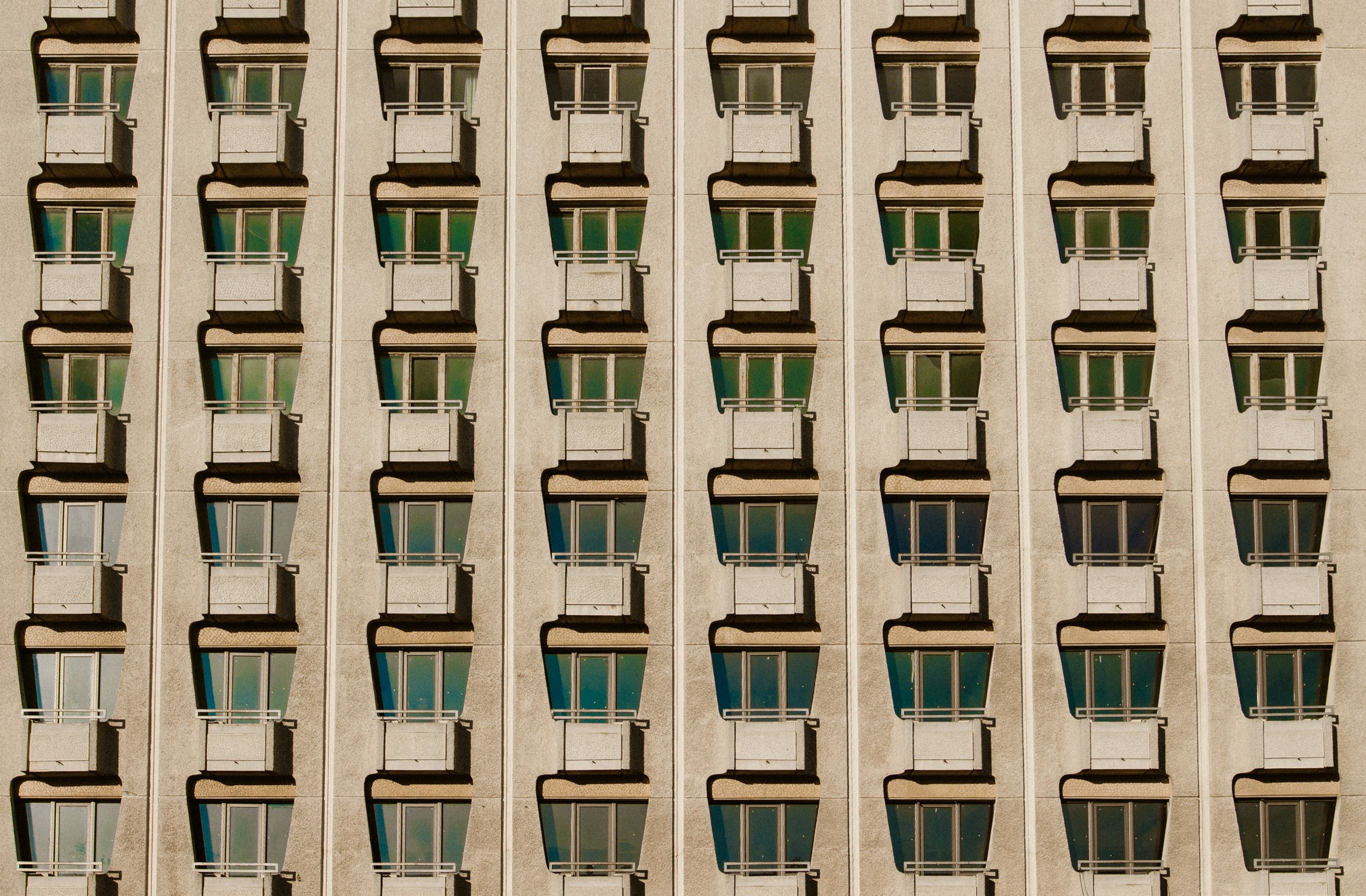 Regular rows of tiny balconies on an old apartment building